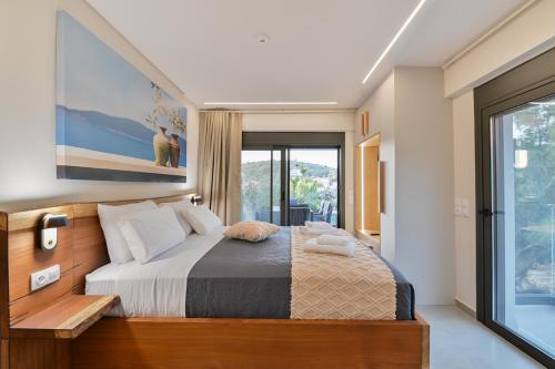 a bedroom with a large bed and a large window at September15 Suites- Meganisi in Meganisi