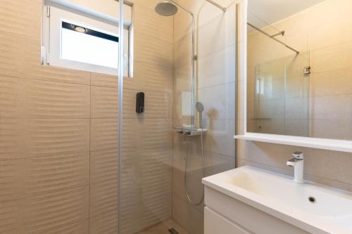 a bathroom with a shower and a sink at Villa SHARK 2 with a pool in Novalja