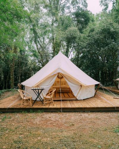 a tent with chairs and a table on a wooden deck at Camping Santa Elena in Lloret de Mar