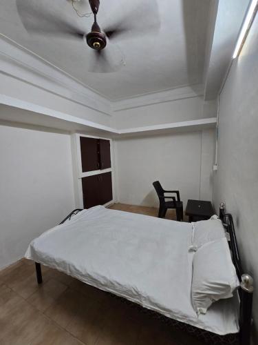 a bedroom with a bed with a ceiling fan at Marhaba Guest House - Budget in Chennai
