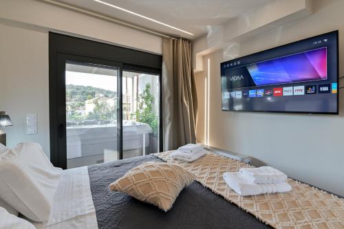 a bedroom with a bed with a flat screen tv on the wall at September15 Suites- Meganisi in Meganisi