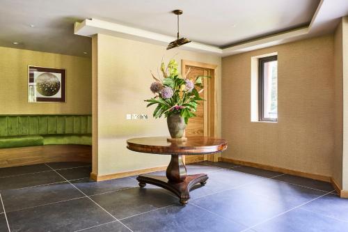 a vase of flowers on a table in a hallway at Hazel Tree Lodge Bunclody in Bunclody