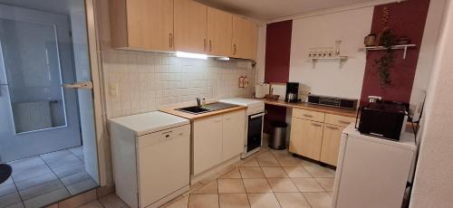 a small kitchen with a sink and a refrigerator at Neukalener Stadthaus Zum Alten Schmied in Neukalen