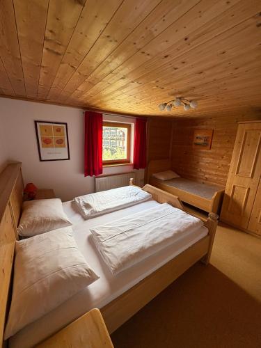 two beds in a room with a wooden ceiling at Ferienhof Kohler in Fügen