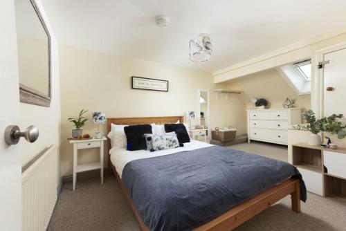 ein Schlafzimmer mit einem Bett mit einer blauen Bettdecke in der Unterkunft Bessie Ellens Cottage in Fowey