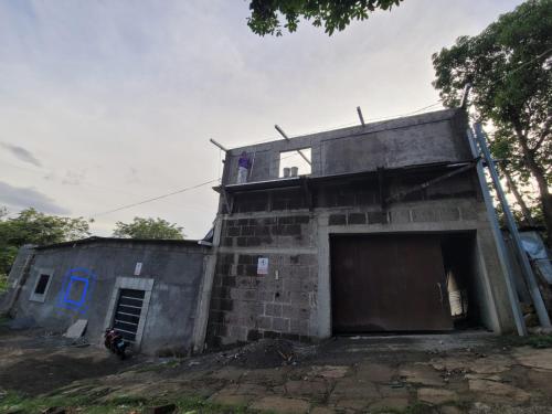 a building with a garage and a motorcycle in front of it at Residential House in Juigalpa