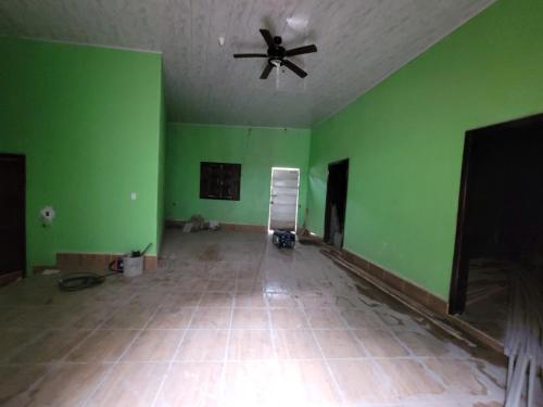 an empty room with a ceiling fan and green walls at Residential House in Juigalpa