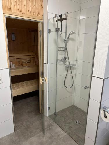 a shower with a glass door in a bathroom at Ferienhaus Meerweh mit Sauna in Butjadingen