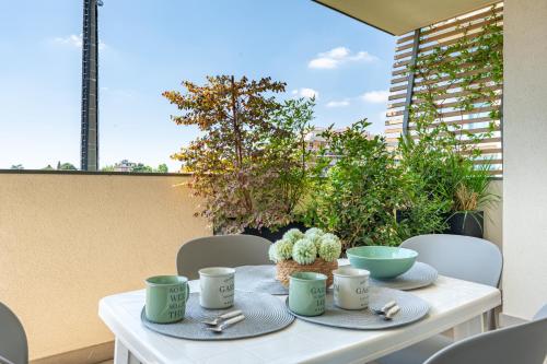 a white table with mugs and cactuses on it at Light Garden-Luxury apartment with private parking in Monza