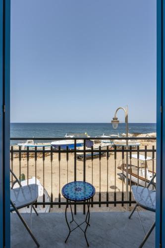 a balcony with a table and chairs and the beach at The twins Rooms in Marettimo 2 in Marettimo