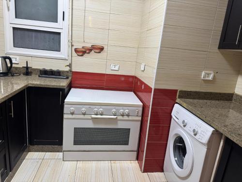 a kitchen with a stove and a washing machine at Zayed continental Apartment in Sheikh Zayed