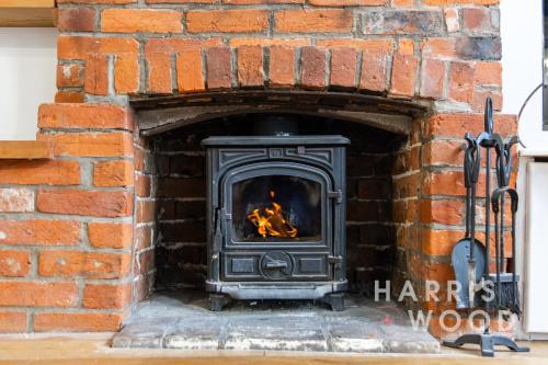 a brick oven with a fire in it at Saltmarsh Cottage in Brightlingsea