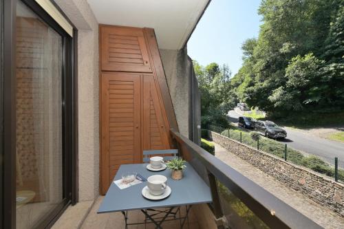 - une table sur un balcon avec vue sur la rue dans l'établissement Appartement au coeur de la vallée, à Luchon