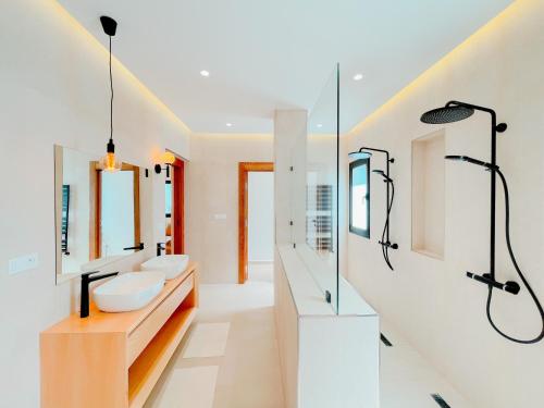 a bathroom with two sinks and two mirrors at Villa Ambre : détente piscine privée hammam in La Marsa