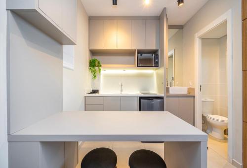 cocina con encimera blanca en una habitación en Flat moderno e aconchegante no Ecoville, en Curitiba