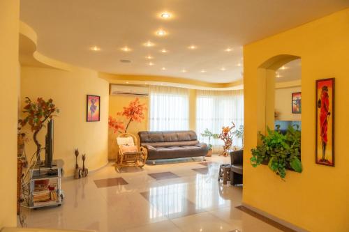 a living room with a couch in the middle at Family Hotel Mimosa in Tsarevo