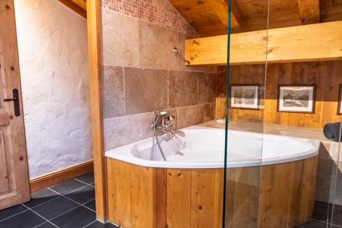 Cette chambre comprend une salle de bains pourvue d'une grande baignoire. dans l'établissement Amazing Chalet with Hot Tub Sauna and Panoramic View, à Chamonix-Mont-Blanc