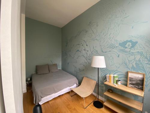 une petite chambre avec un lit et une chaise dans l'établissement Quiet and bright loft, à Paris