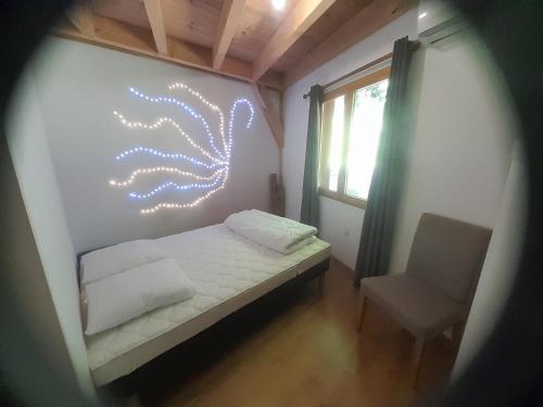 une petite chambre avec un lit et une chaise dans l'établissement Ma maison insolite au cœur des Cévennes, à Vébron