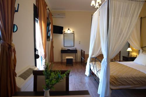 a bedroom with a canopy bed and a desk at Hotel Agnanti Unique Hospitality in Kastoria
