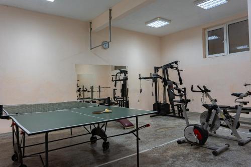 a gym with a ping pong table and exercise bikes at Family Hotel Mimosa in Tsarevo