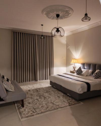 a bedroom with a large bed and a couch at وادي العقيق 202 in Al Madinah