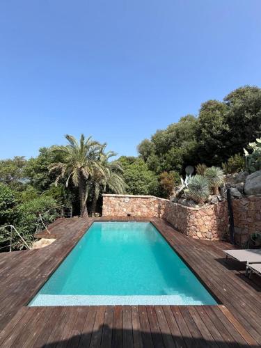a swimming pool with a wooden deck and a swimming pool at Torraccia in Porto-Vecchio