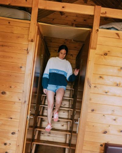 a woman is walking down a ladder in a room at Camping Santa Elena in Lloret de Mar