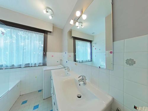 a white bathroom with a sink and a mirror at Appartement au centre - 3 pièces, 6 personnes, ascenseur - FR-1-241-222 in Le Grand-Bornand
