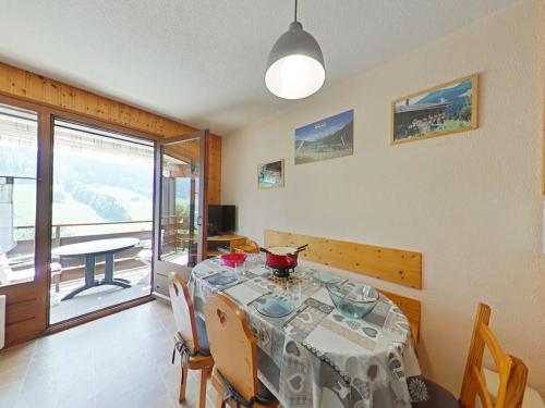 une salle à manger avec une table et un balcon dans l'établissement Studio cabine 4 pers avec terrasse et garage, proche navettes ski - Le Grand-Bornand - FR-1-241-242, au Grand-Bornand