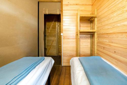 a room with two beds in a wooden room at Lodge 3 - Domaine Des Landes in Lesperon