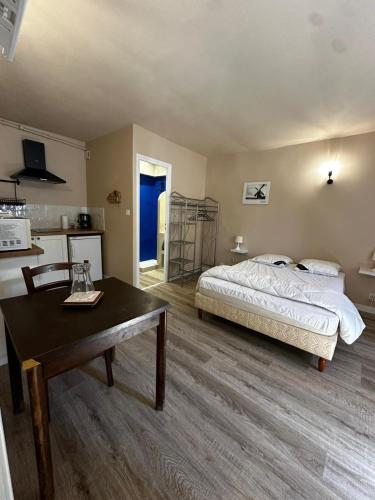a bedroom with a bed and a table in it at Studio 4 Aux volets bleus in Aulus-les-Bains