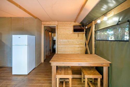 a small kitchen with a table and a refrigerator at Lodge 3 - Domaine Des Landes in Lesperon