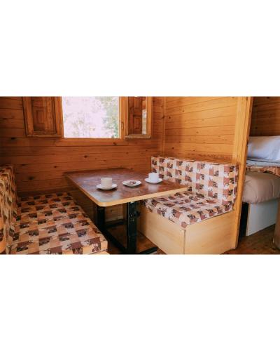 a room with a bench and a table and a bed at Camping Santa Elena in Lloret de Mar