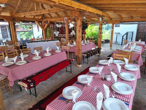 un ristorante con tavoli e sedie rossi e bianchi di Etno selo Lelić a Valjevo