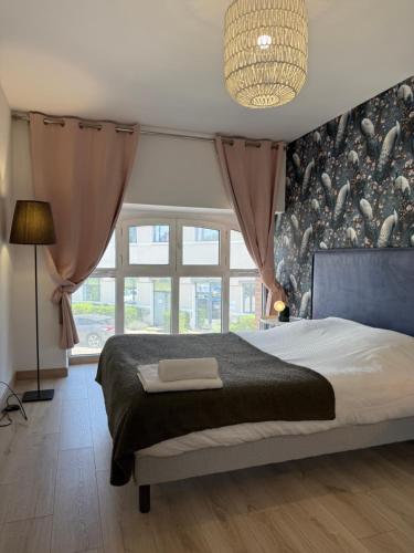 a bedroom with a bed and a large window at Escale moderne et chaleureux in Auxerre