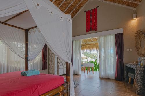 a bedroom with a canopy bed and a dining room at Coco Verde Bali Resort in Tanah Lot