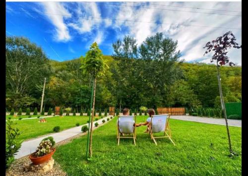 two people sitting in chairs in the grass at Sicevacka Bajka in Niš