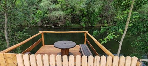 a wooden dock with a wooden table on a river at Sicevacka Bajka in Niš