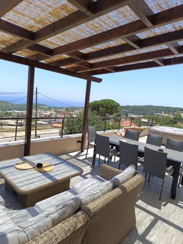 a patio with a couch and a table and chairs at Arsithea Villa in Monólithos