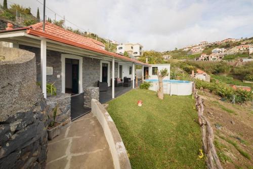 a stone house with a yard with a swimming pool at Casa do Vale by Mth in Ribeira Brava