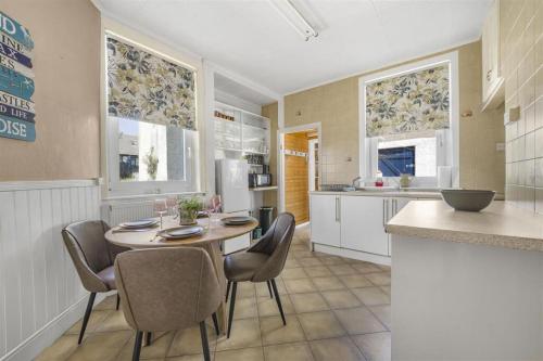 a kitchen with a table and chairs and a counter at Sea View Home in lovely Ogmore-by-Sea in Tythegston
