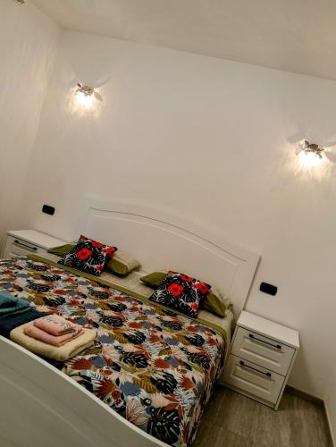 a small bedroom with a bed with a floral bedspread at Stella di mare - appartamenti vista incantevole su Moneglia in Moneglia