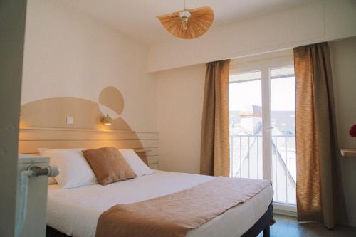 a hotel room with a bed and a large window at Hôtel Dune Saint-Pierre in Saint-Pierre-Quiberon