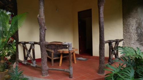 a room with a chair and a table and trees at Vijiji Center Lodge and Safari in Arusha
