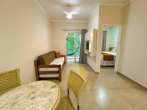 a living room with a table and chairs and a bedroom at Hotel Nacional Inn Guarujá in Guarujá