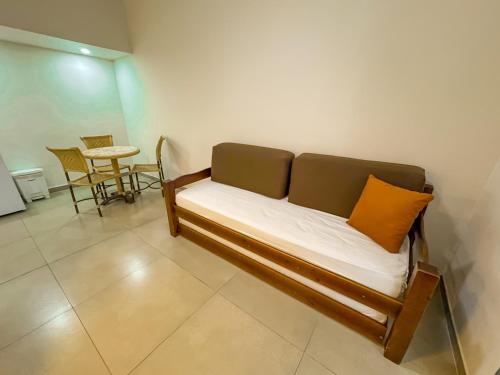 a couch with an orange pillow in a room at Hotel Nacional Inn Guarujá in Guarujá