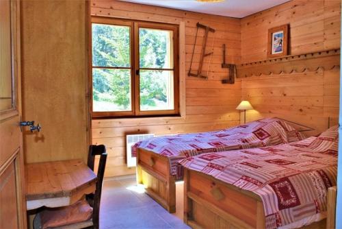 a bedroom with two beds and a window at L'Evasion Authentique - Nature & Cheminée in Les Thuiles