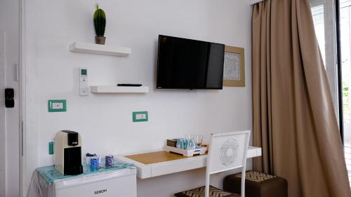 a room with a desk and a tv on the wall at Rooms Apartaments Santa Teresa in Capo Testa