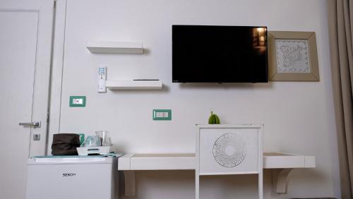 a flat screen tv hanging on a white wall at Rooms Apartaments Santa Teresa in Capo Testa